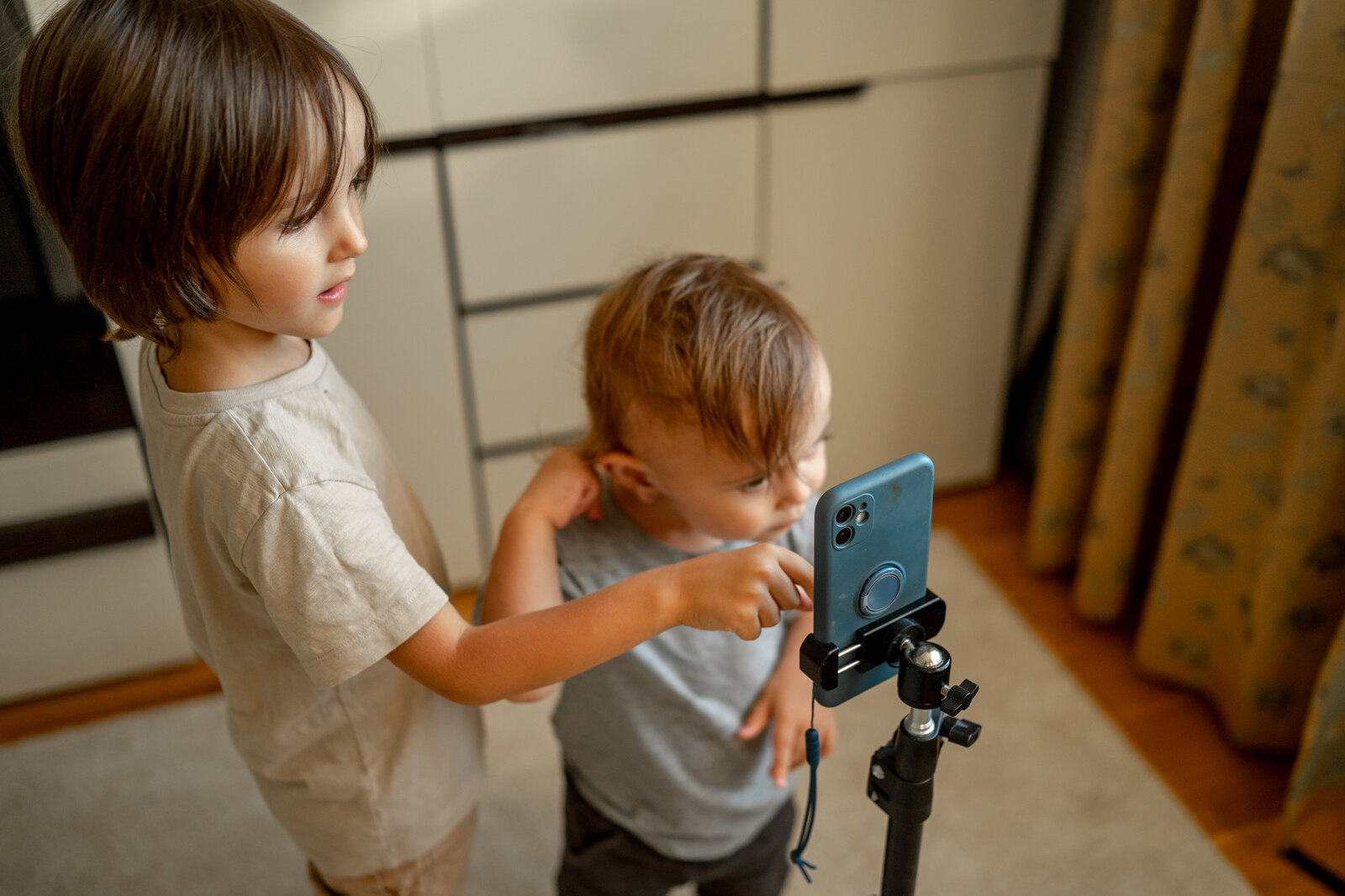 Criança usando dispositivo digital em casa, ilustrando os impactos do uso excessivo de telas digitais no desenvolvimento cognitivo infantil